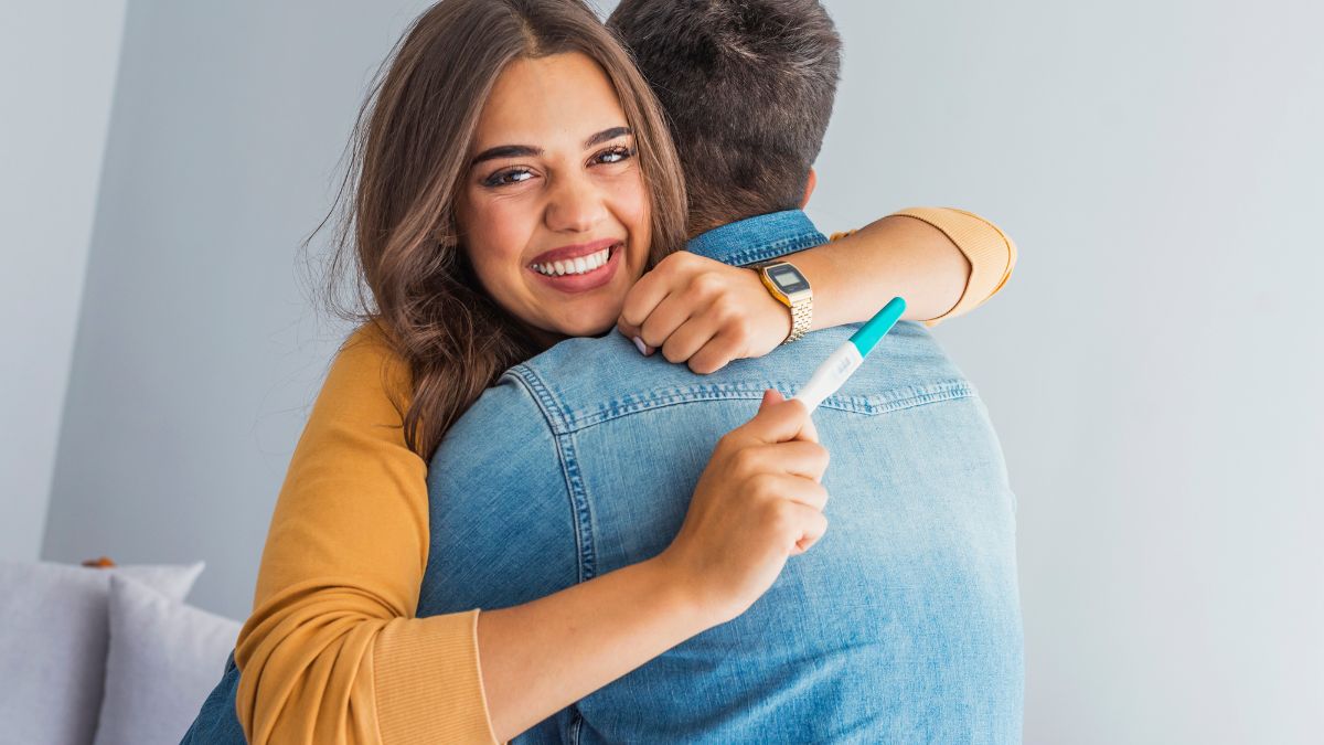 picture of happy couple with a celebrating a positive pregnancy test